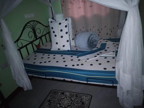 1 dormitorio con cama con colcha de lunares en Eyasi Safari Motel, en Mangola
