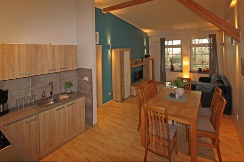 a kitchen and a living room with a table and chairs at Ferienwohnungen Poppelvitz in Altefähr