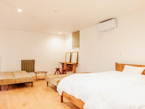 ein Schlafzimmer mit einem weißen Bett und einem Tisch in der Unterkunft AMAZING LIFESTYLE GLAMPING HOTEL - Vacation STAY 44042v in Nagahama