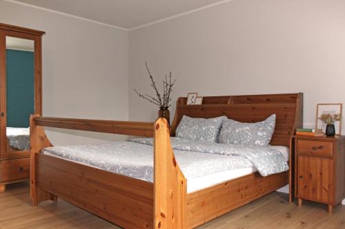 a bedroom with a wooden bed with a wooden frame at Ferienwohnungen Poppelvitz in Altefähr