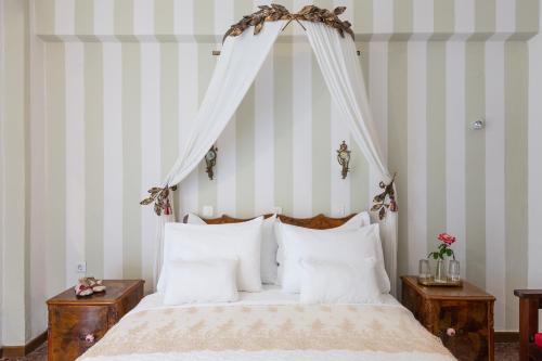 a bedroom with a white bed with a canopy at Liotopi in Olympiada