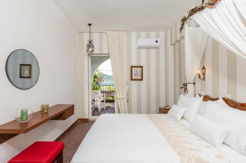 a bedroom with a white bed and a red chair at Liotopi in Olympiada