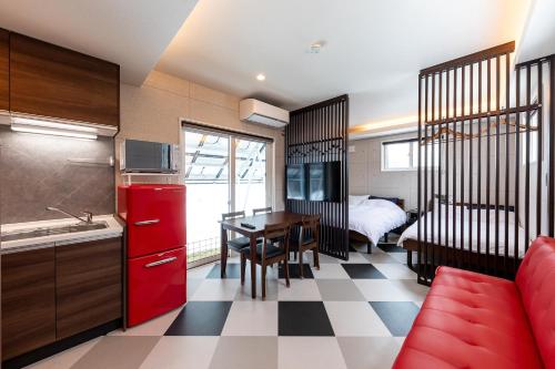 a small kitchen with a red refrigerator and a table at Furano Trailer Village Den in Furano