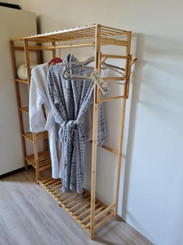 a wooden clothes rack with clothes on it at B&B de Koepeltjes in Zoetermeer