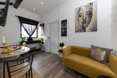 ein Wohnzimmer mit einem gelben Sofa und einem Tisch in der Unterkunft Sea house Lea in Novi Vinodolski