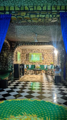a room with a table and chairs on a checkered floor at Châteaux Yolande in Mahajanga