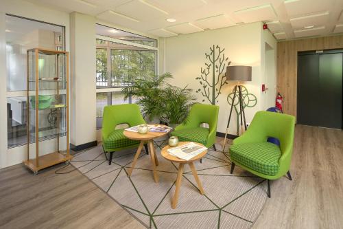 an office with green chairs and a table in a room at Hotel Lindenhof in Bielefeld