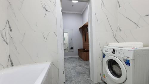 a laundry room with a washer and dryer at Luxembourg in Taldykolʼ
