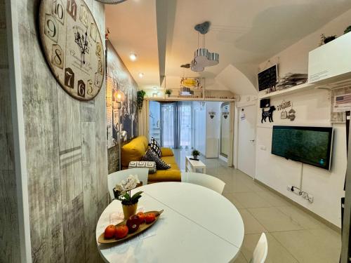 a living room with a table and a clock on the wall at BADAROSA House10min to BARCELONA City&NearTo BEACH in Badalona