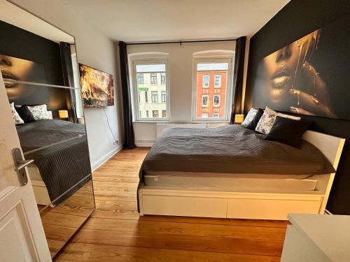 a bedroom with a bed and a large window at TOP Altbauwohnung in Kiel Mitte in Kiel