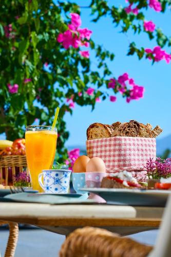 a table with a plate of food and a glass of orange juice at Tourist Boutique Hotel in Argostoli