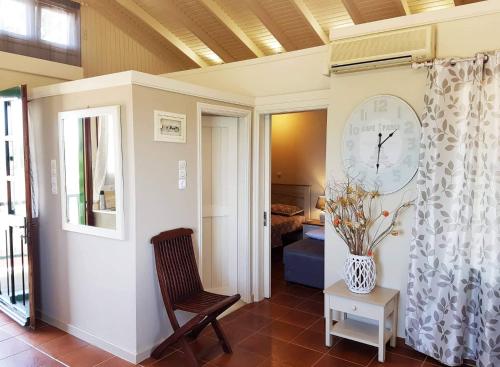 una habitación con una silla y un reloj en la pared en Villa Corali, en Karfas