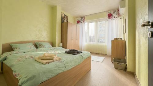 a bedroom with a bed with green sheets and a window at Апартамент Панчо in Sofia