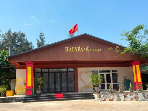 un restaurante con un edificio rojo con un cartel en él en Hải Yến Hotel Quảng Bình, en Dong Hoi