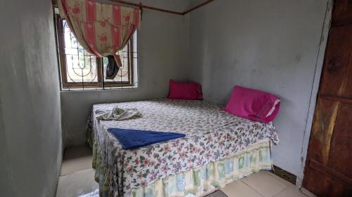 a small bed in a room with a window at Tripple H rent House in Kilindoni