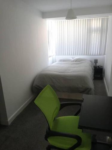 um quarto com uma cadeira verde e uma cama em Double-bed (E2) close to Burnley city centre em Burnley