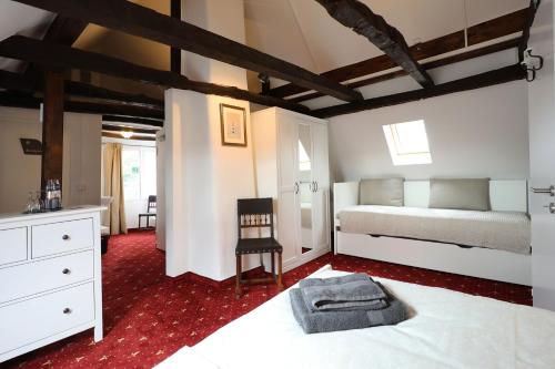 1 dormitorio con 1 cama y 1 silla en una habitación en THE CORNISH ARMS Guest House, en Solingen