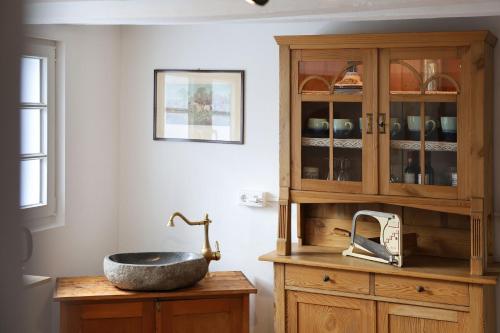 a bathroom with a sink and a wooden cabinet at THE CORNISH ARMS Guest House in Solingen