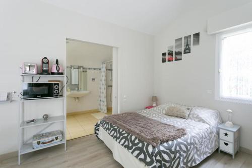 um quarto branco com uma cama e um espelho em studio lumineux au calme em Gif-sur-Yvette