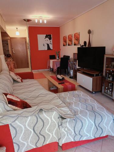 uma sala de estar com uma cama e uma televisão de ecrã plano em Dancer's Home em Corinto