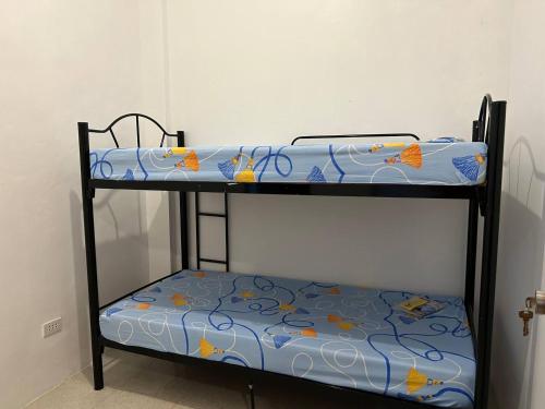 a bunk bed with a blue and yellow bedsheet at Caishen Modern Affordable Apartelle 202 in Silang