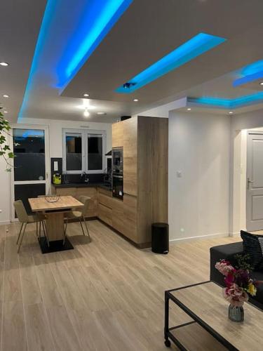 a living room with a table and blue lights at Les Cèdres in Morbier