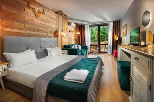 a hotel room with a bed and a living room at Room in BB - Hotel Moura Deluxe Room n5187 in Borovets