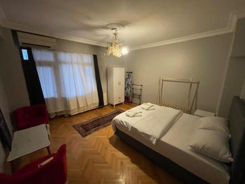 una camera da letto con un grande letto bianco e un lampadario a braccio di Geniş aileler için ideal daire a Istanbul