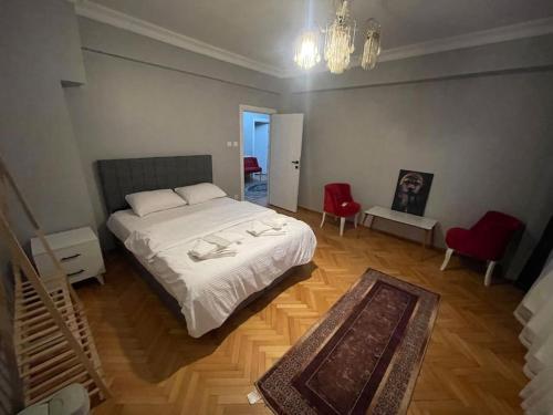 una camera con letto bianco e sedie rosse di Geniş aileler için ideal daire a Istanbul