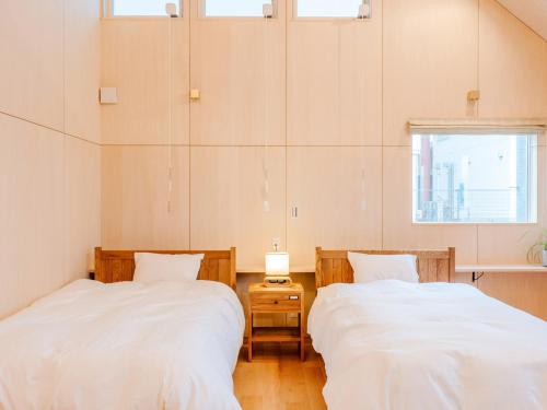 2 Betten in einem Zimmer mit Fenster in der Unterkunft AMAZING LIFESTYLE GLAMPING HOTEL - Vacation STAY 48581v in Nagahama