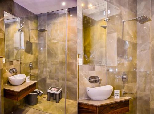 a bathroom with two sinks and a shower at Hotel CJ International in Amritsar