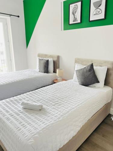 a bedroom with two beds with white sheets at Coastal Luxury Home in Margate in Margate