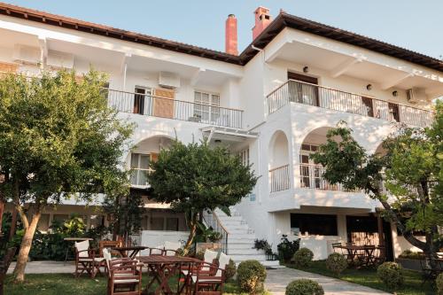 a building with tables and chairs in front of it at Liotopi in Olympiada