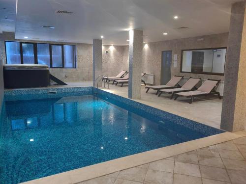 a swimming pool in a hotel with chairs and tables at Chamkoria Chalets in Borovets