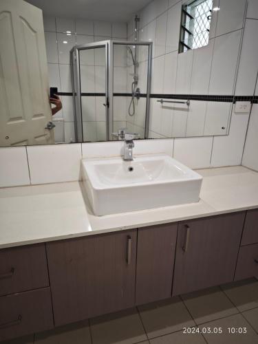 a white sink in a bathroom with a mirror at 1 Pacific FairPrice in Nadi