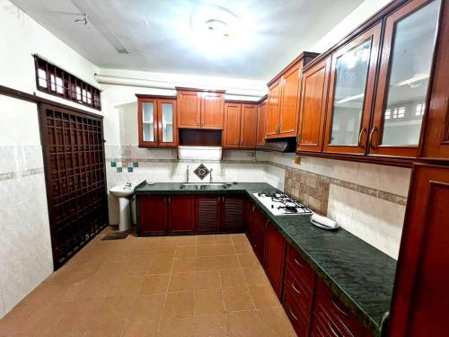 a kitchen with wooden cabinets and a counter top at Private House in the heart of Penang in Gelugor