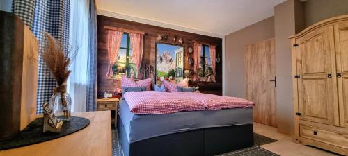 a bedroom with a bed with a wooden headboard at Waldhotel am Turm in Burgholz