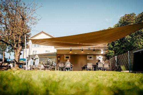a patio with a tan umbrella and tables and chairs at Hirschenwirt in Eichstätt