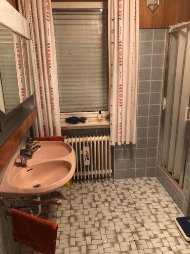 ein Badezimmer mit einem Waschbecken, einem Fenster und einem Heizkörper in der Unterkunft Haus Diepholz in Diepholz