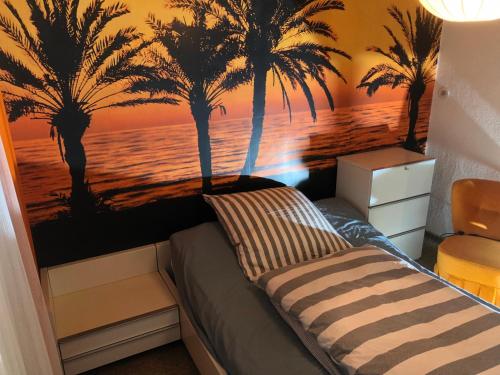Schlafzimmer mit einem Bett mit Palmen an der Wand in der Unterkunft Haus Diepholz in Diepholz