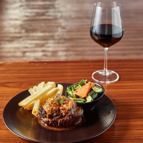 a black plate of food and a glass of wine at Protea Hotel by Marriott Gaborone Masa Square in Gaborone