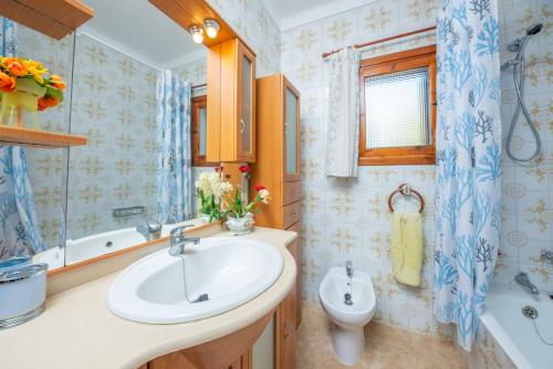 uma casa de banho com um lavatório, uma banheira e um WC. em Casa Caty em Sa Ràpita