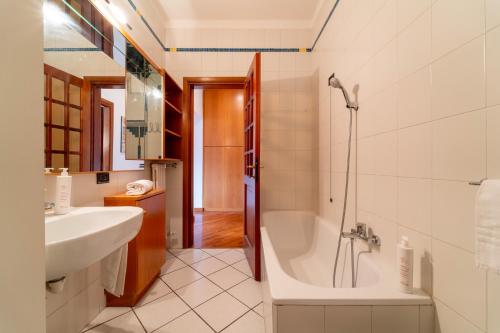 a bathroom with a tub and a sink at Gerbett Apartment with Terrace by Wonderful Italy in Como