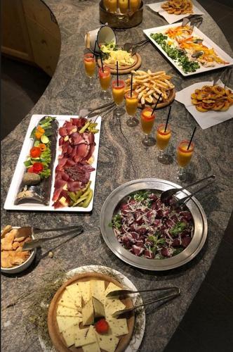 a table with many plates of food and drinks at Dolomitenhotel Weisslahnbad in Tires