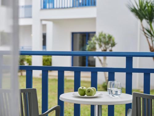 a table with a glass of water and some apples on it at Atlantica Callisto in Ayia Napa