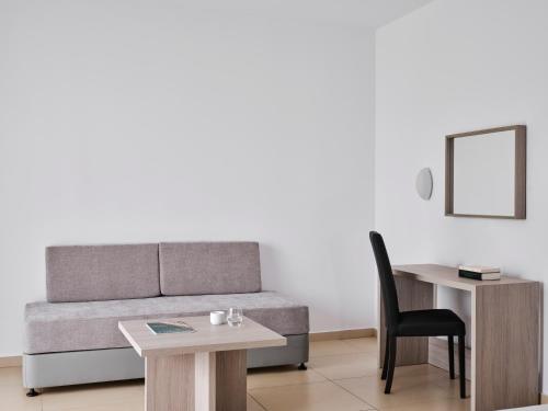 a living room with a couch and a table and a chair at Atlantica Callisto in Ayia Napa