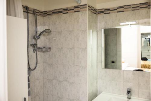 a bathroom with a shower with a sink and a mirror at Casa Vacanza La Fornace Matera centro in Matera