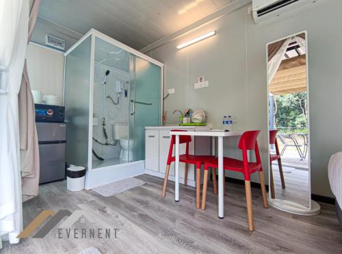 eine Küche mit einem Tisch und roten Stühlen in der Unterkunft Evernent Lakeside Hideout in Miri