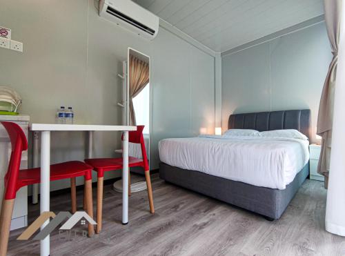 um quarto com uma cama, uma mesa e cadeiras em Evernent Lakeside Hideout em Miri