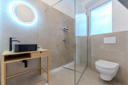 een badkamer met een douche, een toilet en een wastafel bij UrbanSuite in der Innenstadt in Krems an der Donau